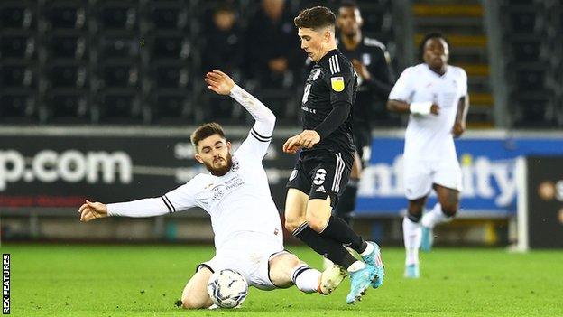 Swansea's Ryan Manning slides in to tackle Harry Wilson of Fulham