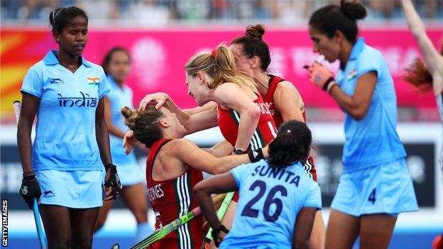 Natasha Marke-Jones of Wales celebrates with Phoebe Richards of Wales and Lisa Daley of Wales after scoring a goal during the Pool A Hockey match between Wales and India on day one of the Gold Coast 2018 Commonwealth Games