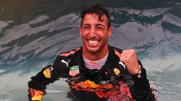 Daniel Ricciardo celebrates in a swimming pool