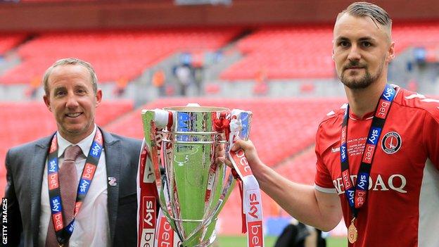 Lee Bowyer and Patrick Bauer celebrate with the League One play-off trophy