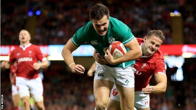 Ireland wing Jacob Stockdale beats Wales' Hallam Amos to score