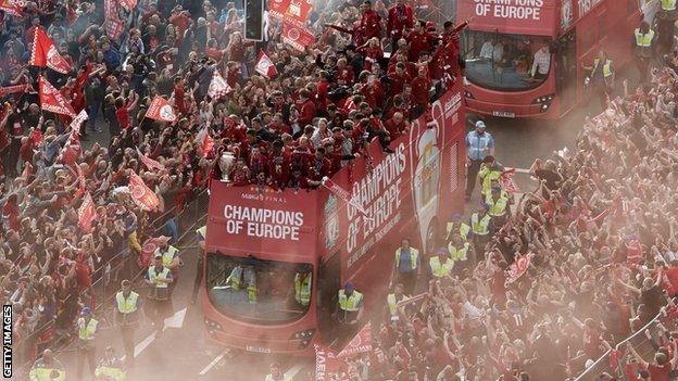 Thousands of fans line the streets as Liverpool parade the Champions League trophy on an open top bus