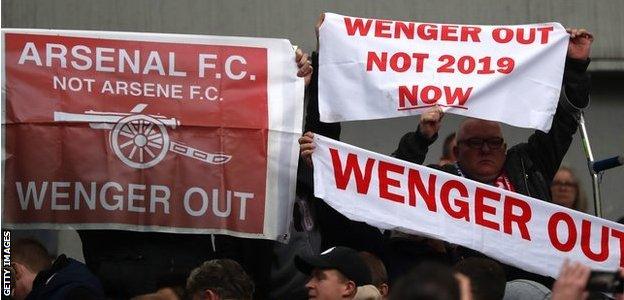 Banners calling for Wenger to leave