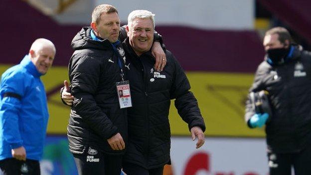 Assistant coach Graeme Jones and manager Steve Bruce celebrate Newcastle's win at Burnley