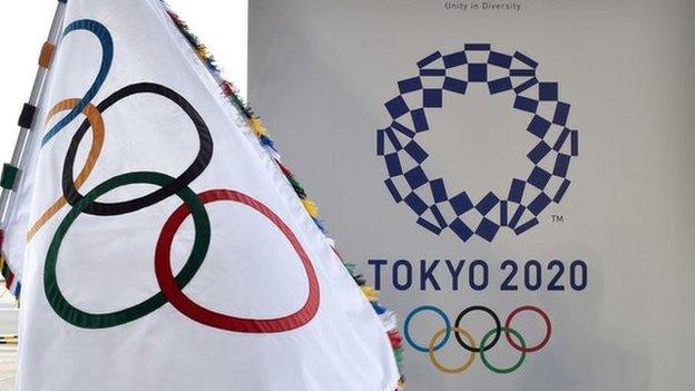 An Olympic flag and the logo of the Tokyo 2020 Games