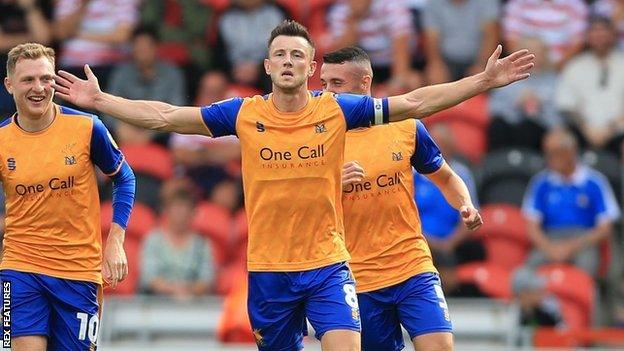 Ollie Clarke celebrates scoring a goal for Mansfield Town