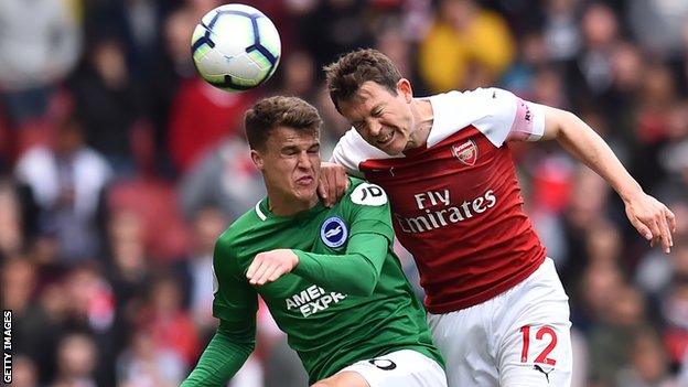 Brighton forward Solly March wins a header against Arsenal right-back Stephan Lichtsteiner