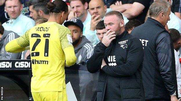 Derby boss Wayne Rooney watches keeper Kelle Roos leave the pitch after being sent off