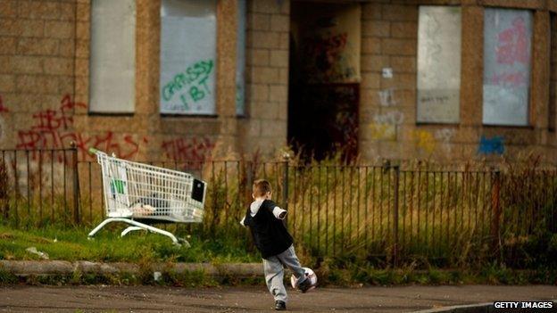 Child playing in rundown housing estate in Glasgow