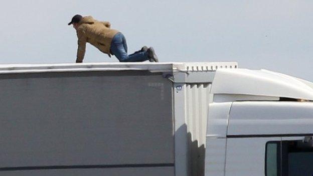 File photo dated 24/06/15 of a migrant trying to board UK bound lorries on the main road into Calais ferry port