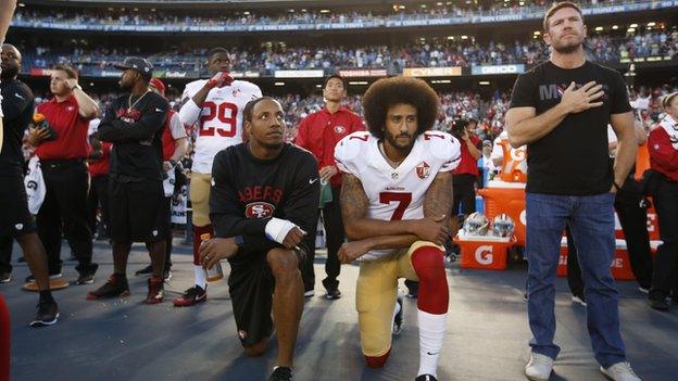 Colin Kaepernick and Eric Reid during the national anthem alongside Nate Boyer