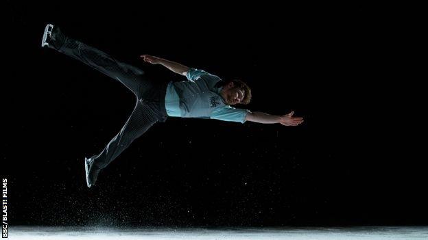 Peter James Hallam performs a jump on the ice.