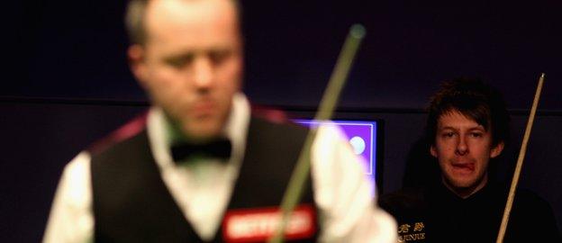 Judd Trump (background) was beaten by John Higgins