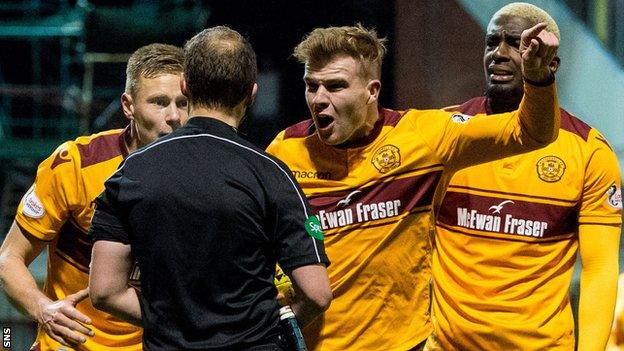 Motherwell players surround referee Willie Collum after he awarded a late penalty