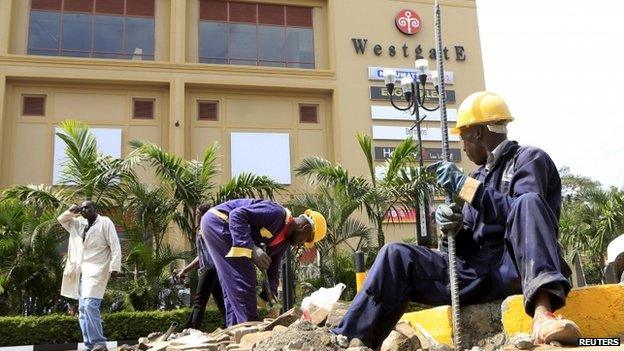 Construction workers dig holes to erect barriers at the reopened Westgate shopping mall