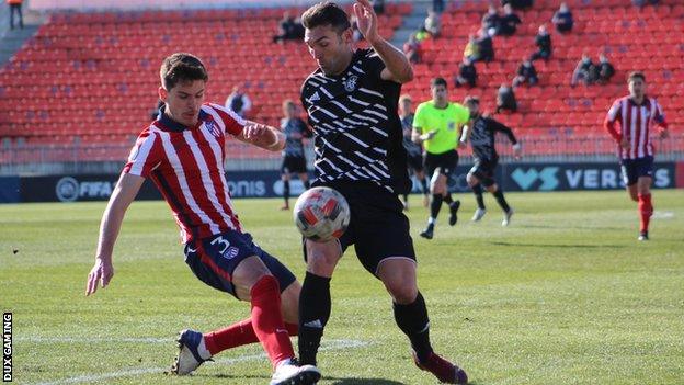 David Barral of DUX Internacional de Madrid challenges for the ball against an Atletico Madrid B player.