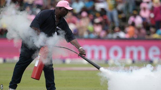 A groundsman uses a fire extinguisher to disperse the bees at the Wanderers