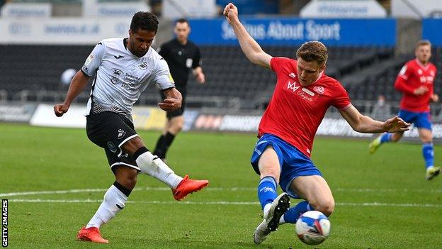 Rob Dickie deflects Wayne Routledge's shot onto the post