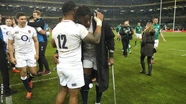 Maro Itoje on crutches hugs Manu Tuilagi