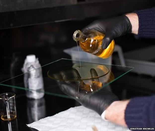 Jack Lowe pouring colloidal silver over glass plate