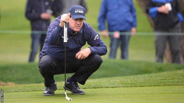 Phil Mickelson lines up a putt