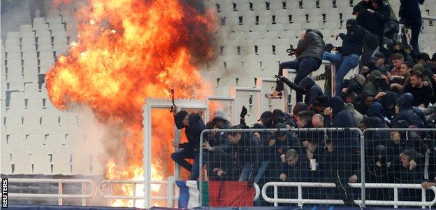 A firebomb lands just short of the Ajax section