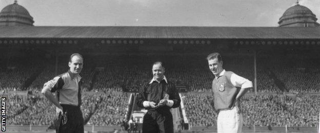 Captains of Bishop Auckland, T Stewart, and Hendon, D Adams, before the kick-off at the Amateur Cup Final beneath the famous twin towers of Wembley Stadium