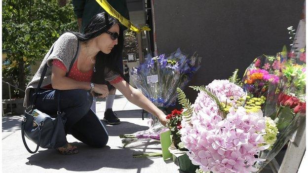 A woman leaves flowers close to the scene of Tuesday's tragedy