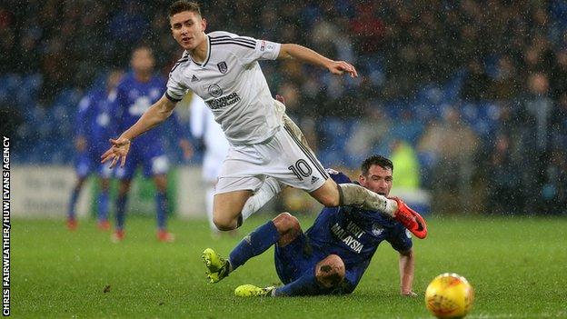 Tom Cairney of Fulham is tackled by Craig Bryson of Cardiff City