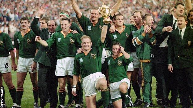 South Africa captain Francois Pienaar holds aloft the Webb Ellis trophy as the rest of the team celebrate