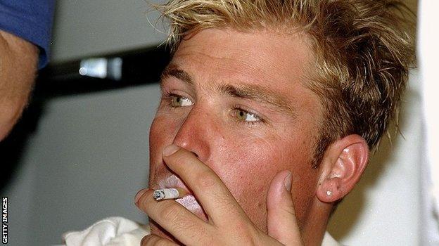 Warne smokes a cigarette