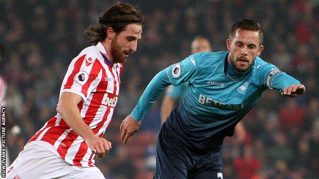 Joe Allen in action against Swansea's Gylfi Sigurdsson.