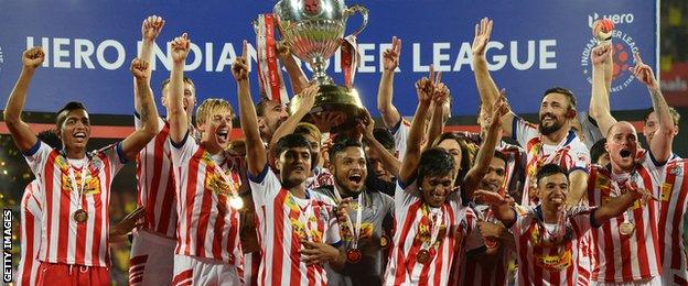 Atletico de Kolkata players celebrate with the trophy after winning the Indian Super League final match against Kerala Blasters FC