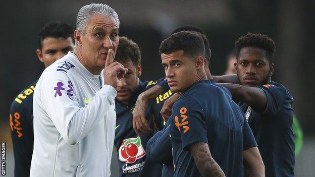 Brazil head coach Tite gestures to fans to be quiet during a training session standing next to his players