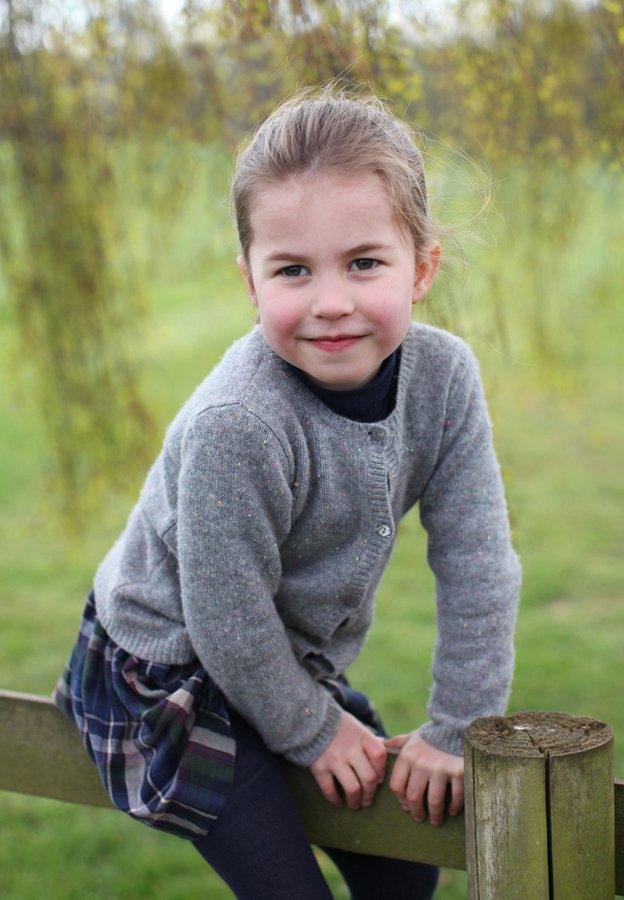 Princess-Charlotte-climbs-over-a-fence-in-her-garden