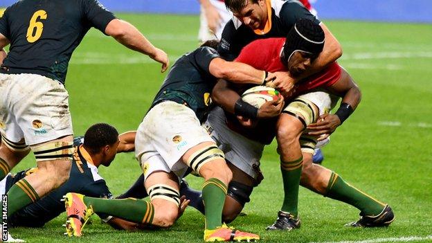 Maro Itoje is tackled by two South Africa players