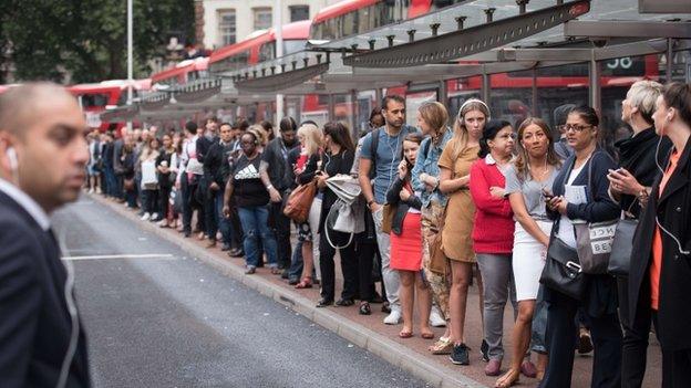 Commuters queue for buses at Victoria station on August 6