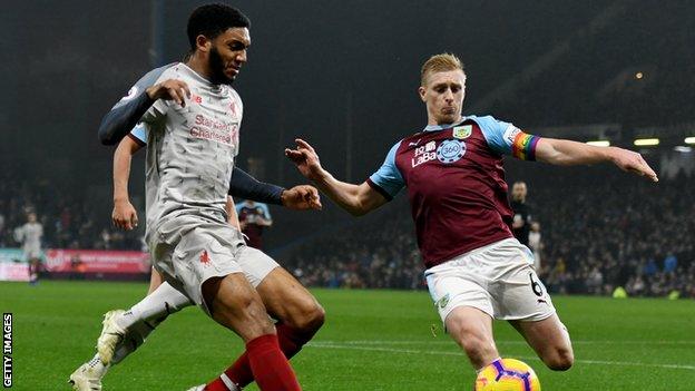 Liverpool defender Joe Gomez (left) goes to challenge Burnley captain Ben Mee (right) for the ball during a Premier League match at Anfield