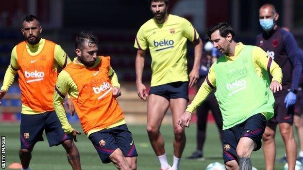 Barcelona superstar Lionel Messi (right) tries to take on team-mate Jordi Alba as the Spanish La Liga leaders step up their phased training