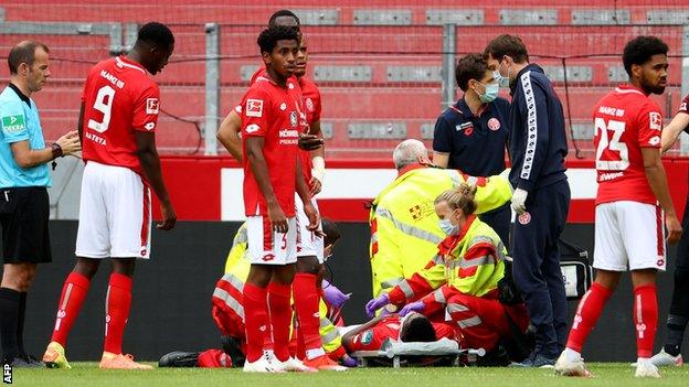 Taiwo Awoniyi receives treatment before being carried off on a stretcher