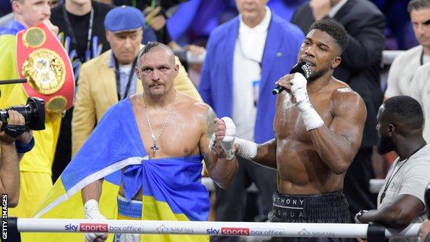 Oleksandr Usyk looks on as Anthony Joshua speaks