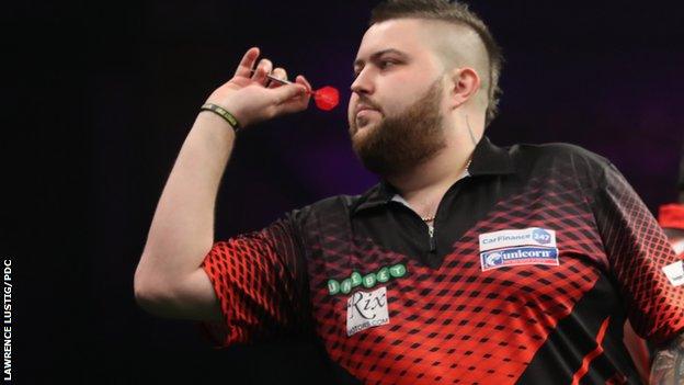 Michael Smith throws a dart