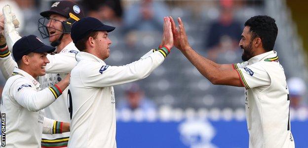 Gloucestershire players celebrate a wicket with Zafar Gohar (right)