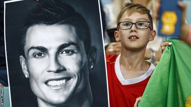 A young Portugal fan with a poster of Cristiano Ronaldo