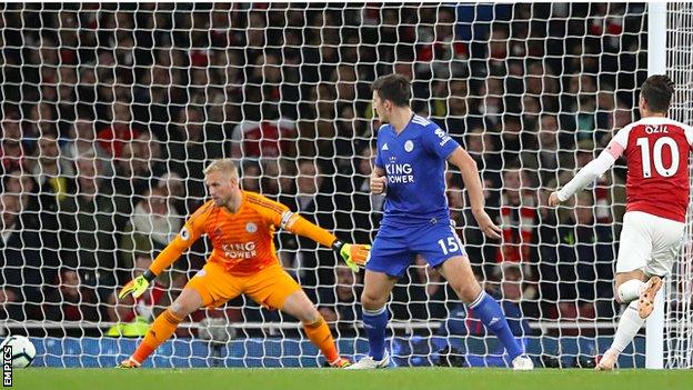 Mesut Ozil (right) scores for Arsenal