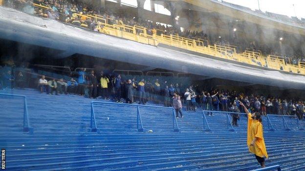 Fans shelter from the rain at Boca's La Bombonera stadium