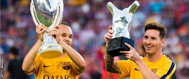 Andres Iniesta shows off the Uefa Super Cup and Lionel Messi the European player of the year trophy