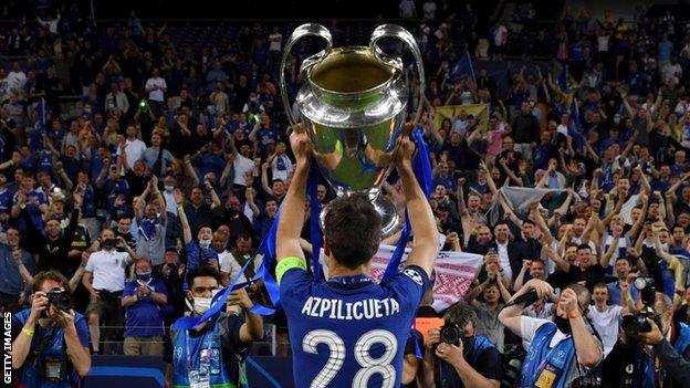 Cesar Azpilicueta holds the trophy up to the fans