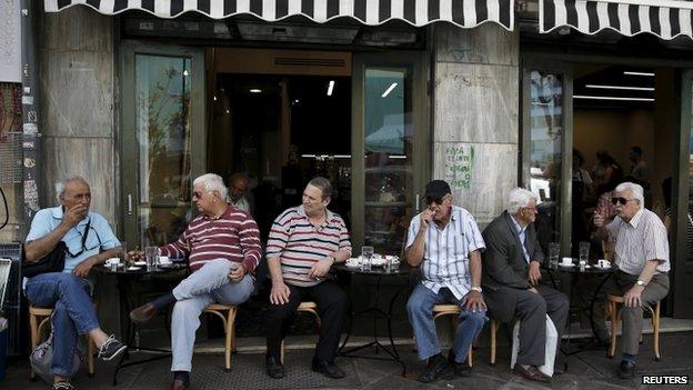 Men sit outside cafe in Athens