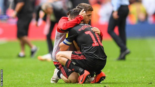 George Honeyman is consoled by a Sunderland team-mate